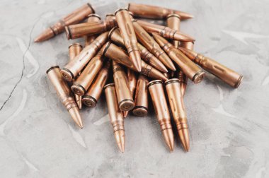 Eski gri kırık beton üzerinde saldırı tüfeği için metal mermi yığını