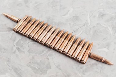 Eski gri kırık beton üzerinde saldırı tüfeği için birçok metal mermi Satır