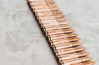 Eski gri kırık beton üzerinde saldırı tüfeği için birçok metal mermi Satır