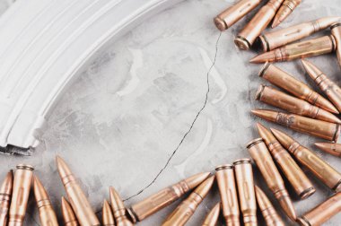 Saldırı tüfeği ve eski gri kırık beton üzerinde birçok dağınık mermi için Gümüş metal tam dergi