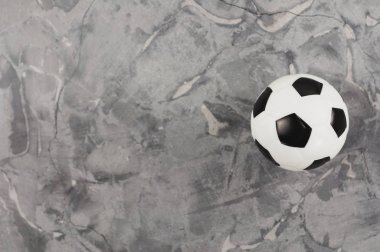 Eski yıpranmış çimento üzerinde yeni bir siyah ve beyaz yumuşak kauçuk futbol topu. Üstte görüntü