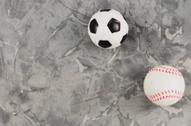 Eski yıpranmış çimento iki yeni yumuşak kauçuk futbol ve beyzbol topları. Üstte görüntü