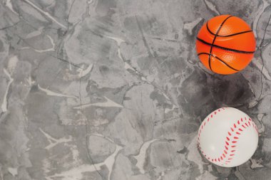 Eski yıpranmış çimento iki yeni yumuşak kauçuk basketbol ve beyzbol topları. Üstte görüntü