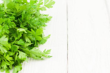 Eski ahşap beyaz rustik plakalar üzerinde yeşil taze çiğ maydanoz yığını