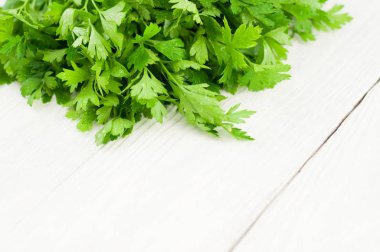 Eski ahşap beyaz rustik plakalar üzerinde yeşil taze çiğ maydanoz yığını