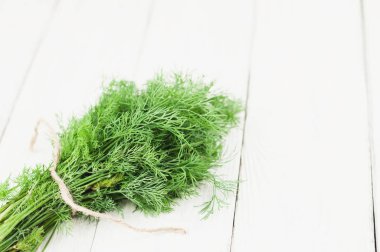 Eski ahşap beyaz rustik plakalar üzerinde kahverengi halat bağlı yeşil taze ham dereotu yığını