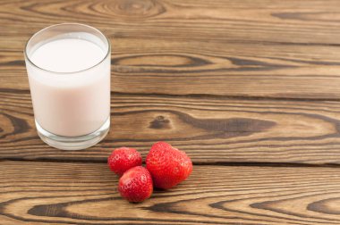 Eski ahşap arka plan üzerinde cam ve tek olgun çilek çilek çilek yoğurt