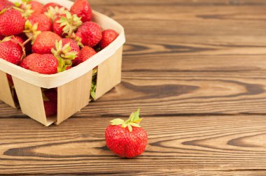 Hasır sepet ve eski rustik ahşap plakalar tek yığın olgun çilek