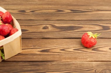 Hasır sepet ve eski rustik ahşap plakalar tek yığın olgun çilek