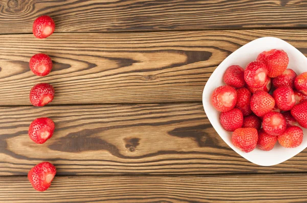 Einzelne Reihe Und Haufen Reife Erdbeeren Schale Auf Altem Holzgrund — Stockfoto