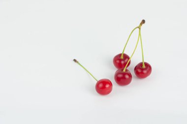 Beyaz arka planda dört kırmızı taze kiraz