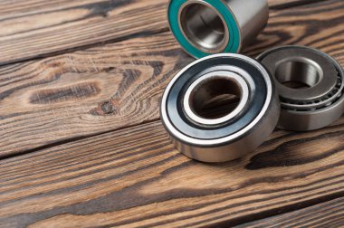 Atölyede eski yıpranmış ahşap masa üzerinde üç kirli parlak metal yatakları ayarlayın. Metniniz için alan kopyalama