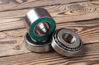 Atölyede eski yıpranmış ahşap masa üzerinde üç kirli parlak metal yatakları seti