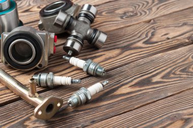 Onarım için farklı otomotiv parçaları set atölye eski yıpranmış ahşap masa üzerinde yatıyor. Metniniz için boşluk kopyalama