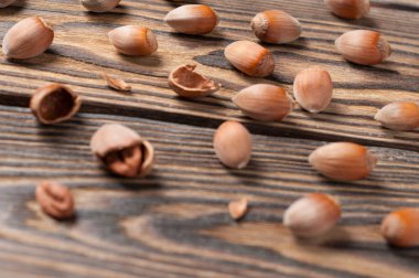 Bütün ve kırık taze olgun fındık mutfakta eski yıpranmış ahşap masa üzerine serpilir