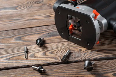 Bir plastik manuel frezeleme makinesi kesiciler ile eski kahverengi rustik ahşap masa üzerinde yatıyor