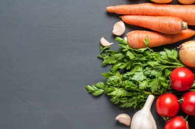 Farklı taze bütün olgun sebze seti koyu beton masa üzerinde yatıyor. Metin için alan kopyalama