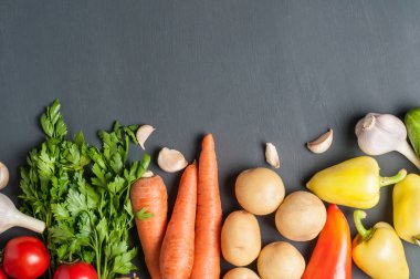 Farklı taze bütün olgun sebze seti koyu beton masa üzerinde yatıyor. Metin için alan kopyalama