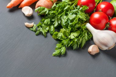 Farklı taze bütün olgun sebze seti koyu beton masa üzerinde yatıyor. Metin için alan kopyalama