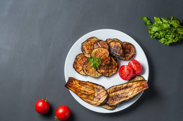 Biała Płyta Ceramiczna Pełna Plastrów Grillowanego Bakłażana Pobliżu Pomidorów Pietruszki — Zdjęcie stockowe