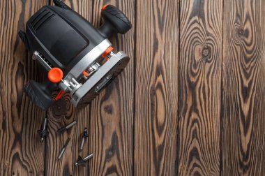 Bir plastik manuel frezeleme makinesi kesiciler ile eski kahverengi rustik ahşap masa üzerinde yatıyor