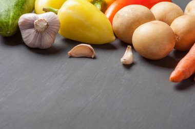 Farklı taze bütün olgun sebze seti koyu beton masa üzerinde yatıyor. Metin için alan kopyalama