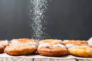 Krema olmadan birçok ev yapımı pişmiş çörekler, eski rustik ahşap masa üzerine düşen pudra şekeri