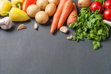 Farklı taze bütün olgun sebze seti koyu beton masa üzerinde yatıyor. Metin için alan kopyalama