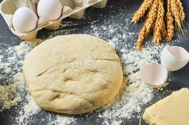 Farklı mutfak eşyaları ve malzemeler yakın un ile Hamur koyu beton masa üzerinde yatıyor. Pişirme işlemi