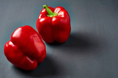 Tüm taze kırmızı biber koyu çizik beton yatıyor. Metin için alan