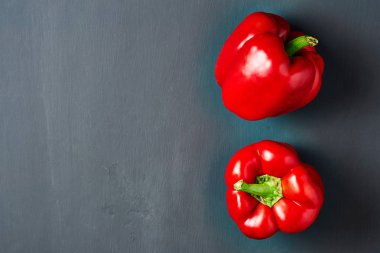 Tüm taze kırmızı biber koyu çizik beton yatıyor. Metin için boşluk. Üstte görüntü