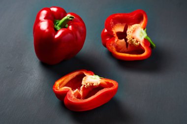 Taze kırmızı biber bütün ve yarım koyu çizik beton yatıyor