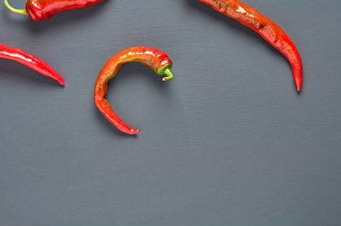 Koyu beton arka plan üzerinde birçok dağınık bütün kırmızı acı biber. Metin için boşluk. Üstte görüntü