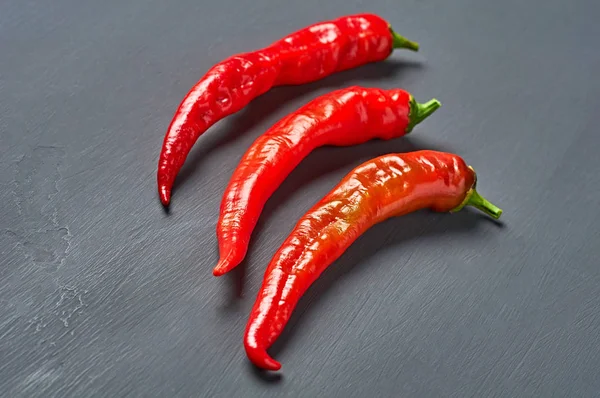 Row Three Wholes Red Hot Chilli Peppers Dark Concrete Background — Stock Photo, Image