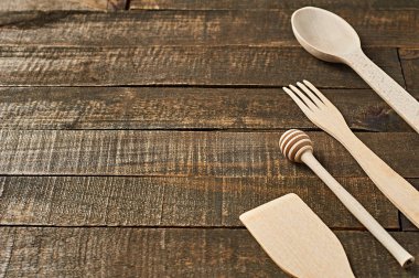 Temiz yararlı ahşap mutfak eşyaları grubu eski rustik plakalar üzerinde yatıyor. Metin için alan