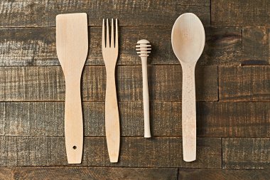 Temiz yararlı ahşap mutfak eşyaları grubu eski rustik plakalar üzerinde yatıyor. Üstte görüntü