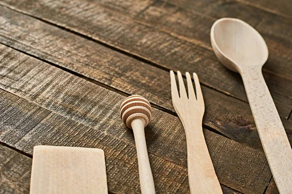 Temiz yararlı ahşap mutfak eşyaları grubu eski rustik plakalar üzerinde yatıyor. Metin için alan