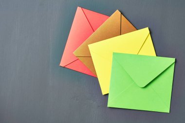 Renkli kare zarflar grubu eski çizik koyu beton yatıyor. Üstte görüntü