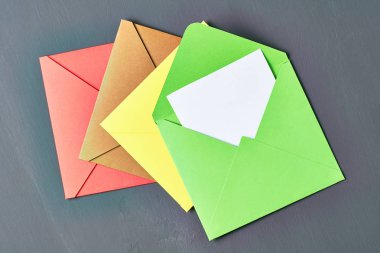 Yeşil açık kare zarf içinde boş beyaz kağıt levha eski çizik koyu beton yatıyor. Metin için boşluk. Üstte görüntü