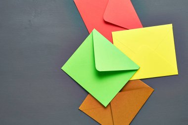 Renkli kare zarflar grubu eski çizik koyu beton yatıyor. Metin için boşluk. Üstte görüntü