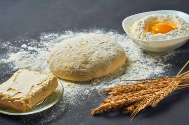 Farklı mutfak eşyaları ve malzemeler yakın un ile Hamur koyu beton masa üzerinde yatıyor. Pişirme işlemi. Kopyalama alanı