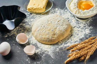 Farklı mutfak eşyaları ve malzemeler yakın un ile Hamur koyu beton masa üzerinde yatıyor. Pişirme işlemi