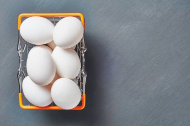 Yumurta dolu pazar sepeti rustik ahşap masaüzerinde yatıyor. Metin için boşluk. Üstte görüntü