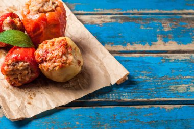 Nane yaprağı ile biber dolması yığını buruşturulmuş kağıt ve eski mavi rustik ahşap masa üzerinde yatıyor. Kopyalama alanı