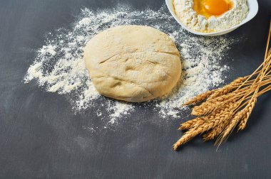 Farklı mutfak eşyaları ve malzemeler yakın un ile Hamur koyu beton masa üzerinde yatıyor. Pişirme işlemi. Kopyalama alanı