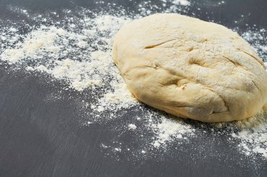 Un lu hamur topu koyu beton masanın üzerinde dir. Pişirme işlemi. Kopyalama alanı