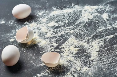 Un üzerine bütün yumurta ve kabukları koyu beton masada yatıyor. Pişirme işlemi. Kopyalama alanı