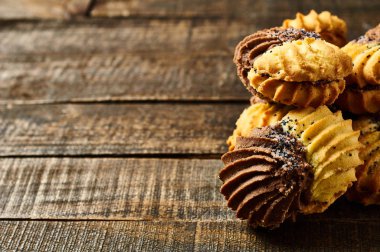 Eski rustik masada krema ve haşhaş ile çift renkli kurabiye yığını. Metin için alan