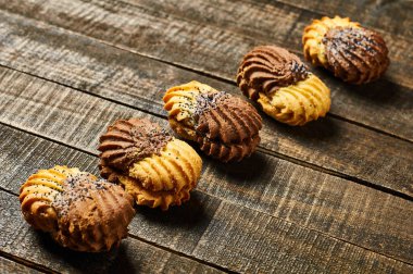 Eski rustik masada krema ve haşhaş ile çift renkli kurabiye Satır