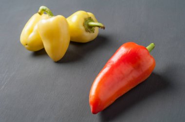 Dağınık bütün taze olgun biber koyu çimento masada yatıyor. Metin için alan kopyalama